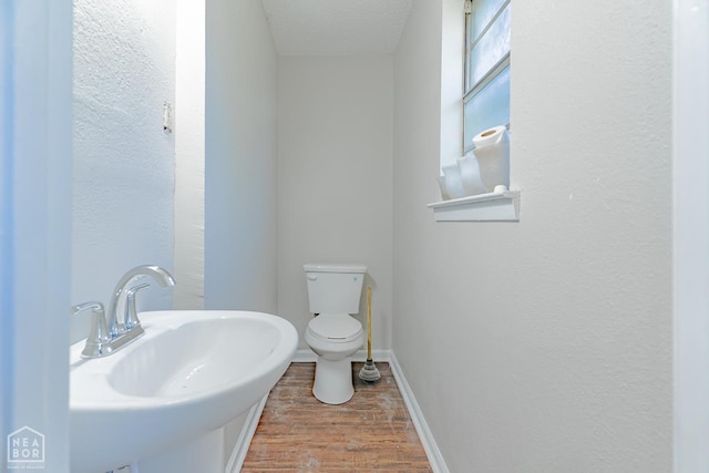 325 S 12th St, West Memphis, AR 72301 - bathroom featuring a sink, wood finished floors, toilet, a textured ceiling, and baseboards