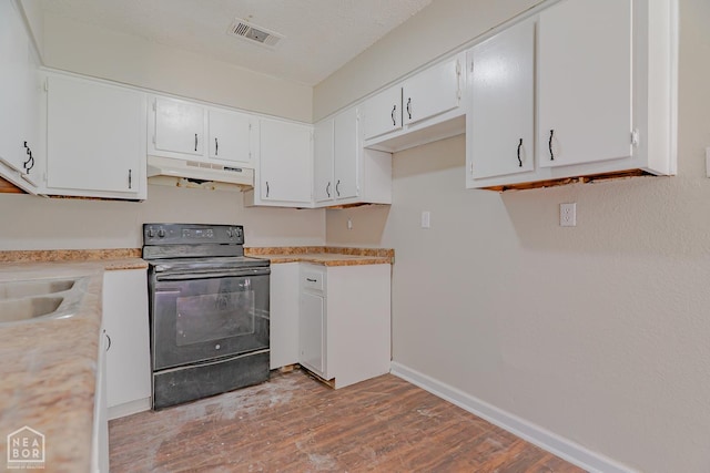 325 S 12th St, West Memphis, AR 72301 - kitchen with black range with electric cooktop, under cabinet range hood, light wood-style floors, light countertops, and white cabinetry