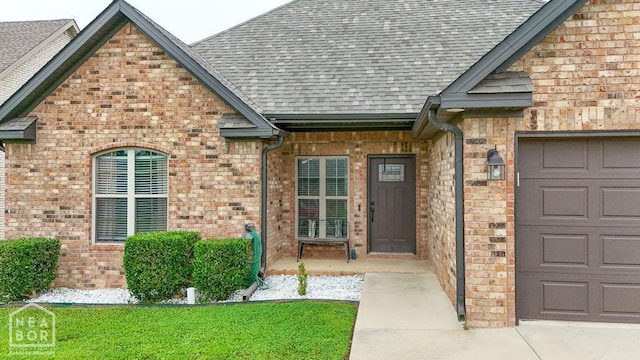 509 Wiregrass Way, Jonesboro, AR 72405 - entrance to property with roof with shingles, an attached garage, and brick siding