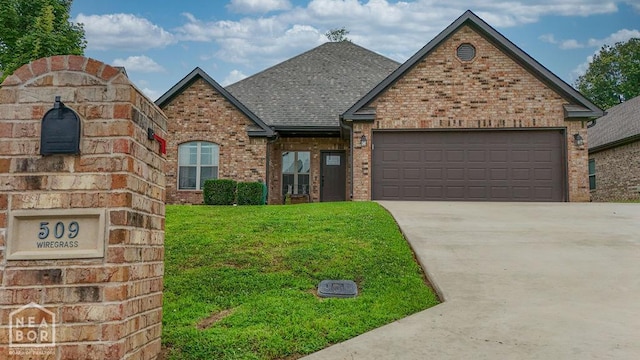 509 Wiregrass Way, Jonesboro, AR 72405 - view of front of home featuring brick siding, driveway, an attached garage, a front yard, and a shingled roof
