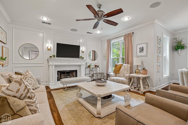 3821 Pebble Beach Dr, Jonesboro, AR 72404 - living room with crown molding, a ceiling fan, light wood-style floors, a fireplace with flush hearth, and baseboards
