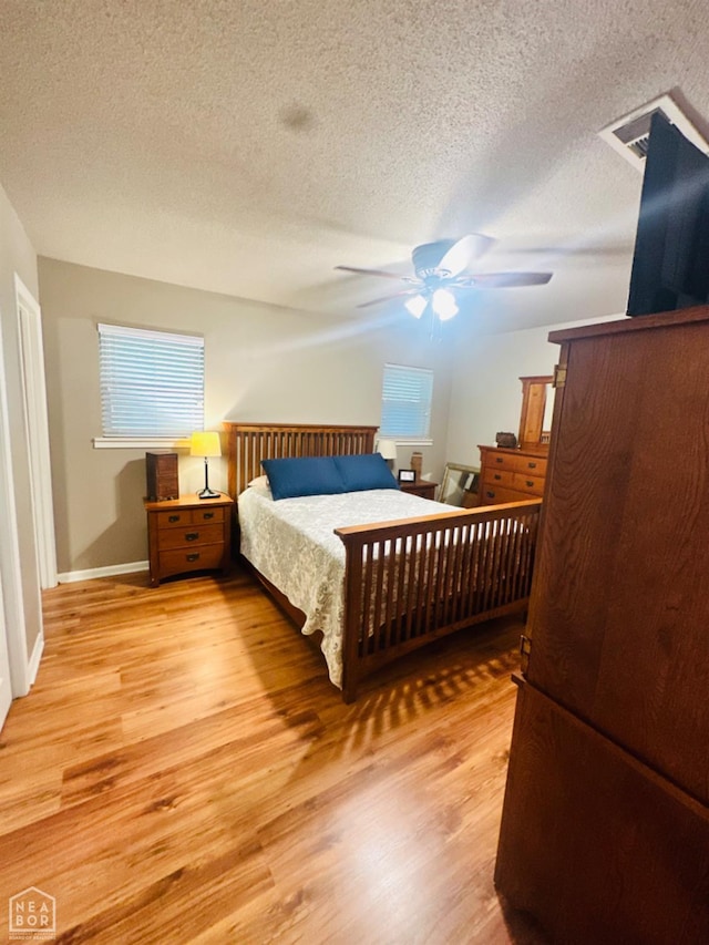 2804 Ivy Dr, Newport, AR 72112 - bedroom with light wood-style flooring, a textured ceiling, baseboards, and a ceiling fan