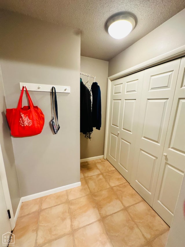 2804 Ivy Dr, Newport, AR 72112 - mudroom featuring a textured ceiling, light tile patterned flooring, and baseboards