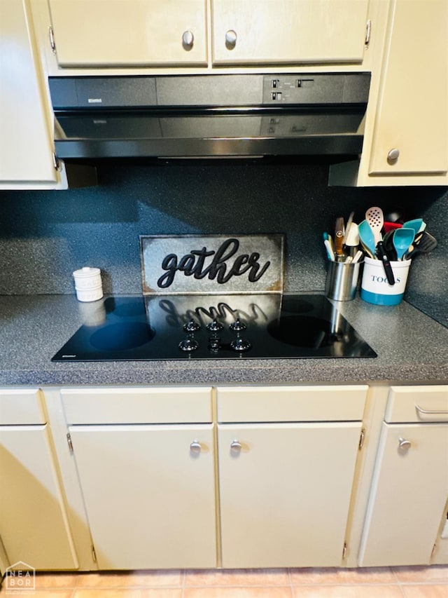 2804 Ivy Dr, Newport, AR 72112 - kitchen view of under cabinet range hood, black electric cooktop, white cabinets, and backsplash