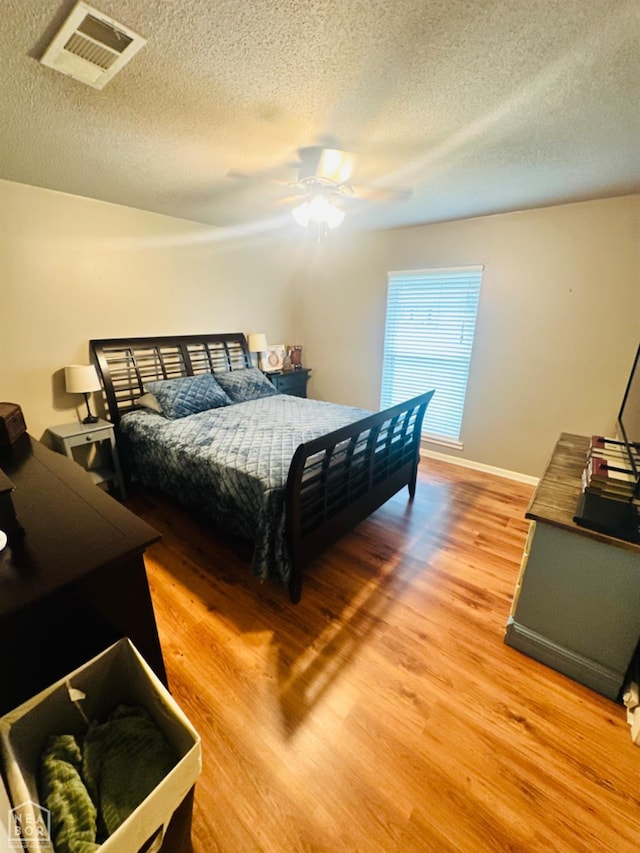2804 Ivy Dr, Newport, AR 72112 - bedroom featuring light wood-style flooring, a textured ceiling, a ceiling fan, and baseboards