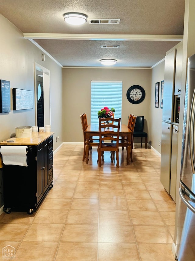 2804 Ivy Dr, Newport, AR 72112 - dining room with a textured ceiling, ornamental molding, light tile patterned flooring, and baseboards