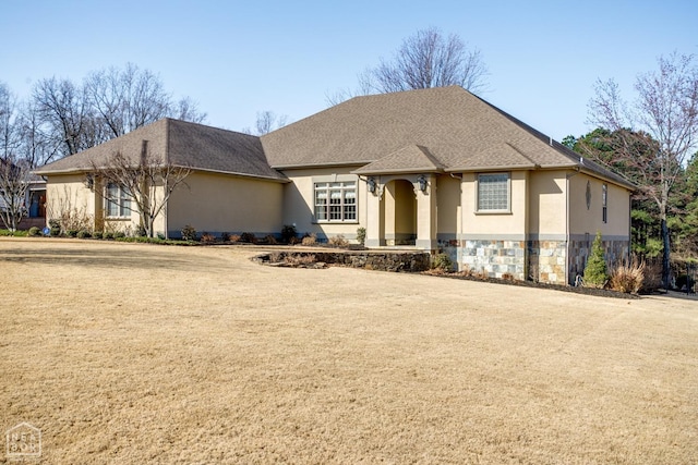 view of front of home featuring a shingled roof, stucco siding, stone siding, and a front lawn