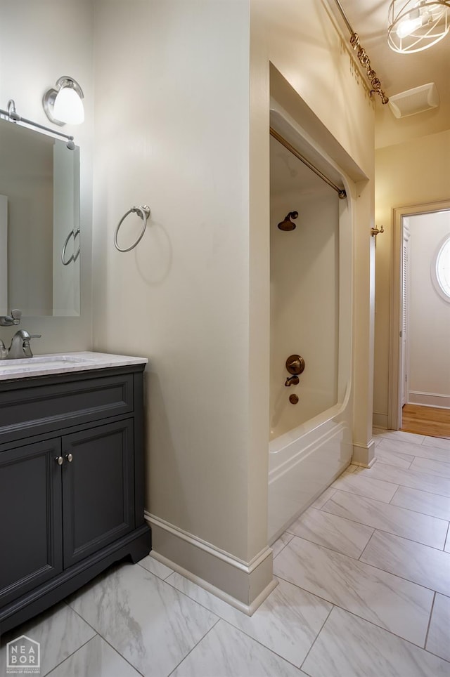 bathroom featuring baseboards, vanity, marble finish floor, and shower / bathing tub combination