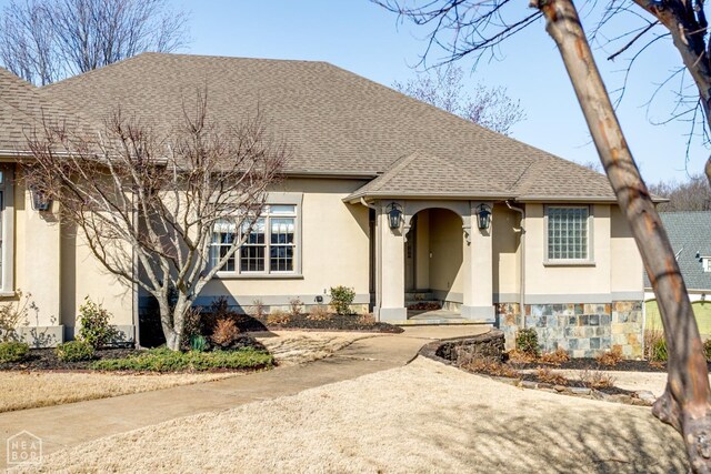 view of front of home with roof with shingles and stucco siding