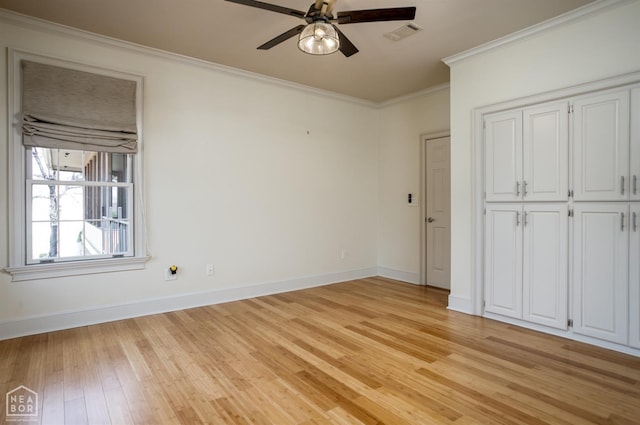 unfurnished bedroom featuring visible vents, baseboards, a closet, light wood-style floors, and crown molding