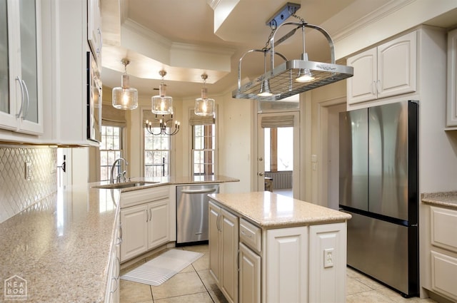 kitchen with a sink, ornamental molding, a wealth of natural light, and appliances with stainless steel finishes