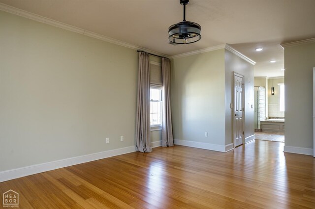 spare room with baseboards, recessed lighting, light wood-type flooring, and crown molding