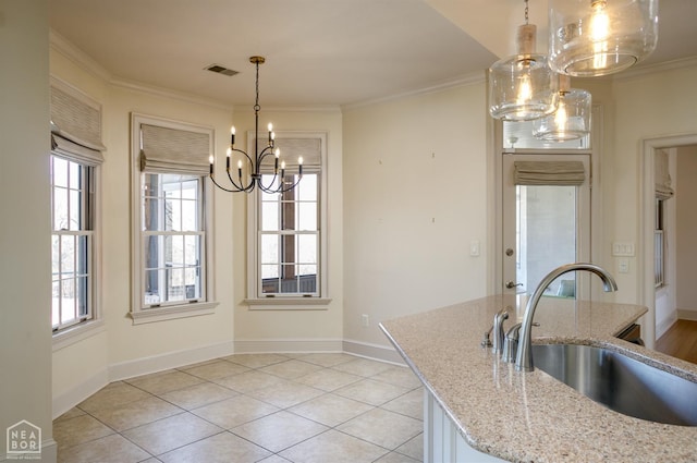 kitchen featuring pendant lighting, ornamental molding, visible vents, a sink, and a notable chandelier