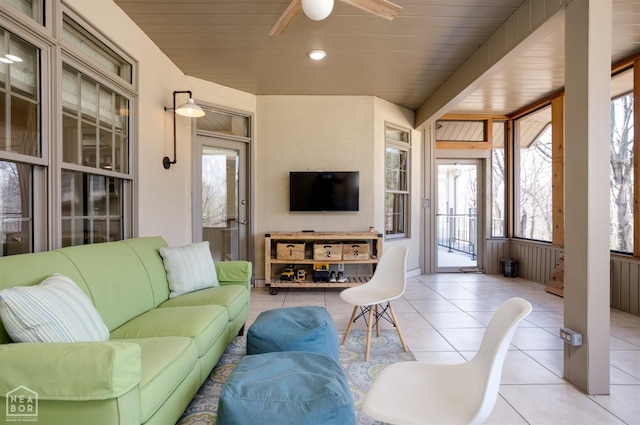 living area featuring a ceiling fan, wooden ceiling, and tile patterned flooring