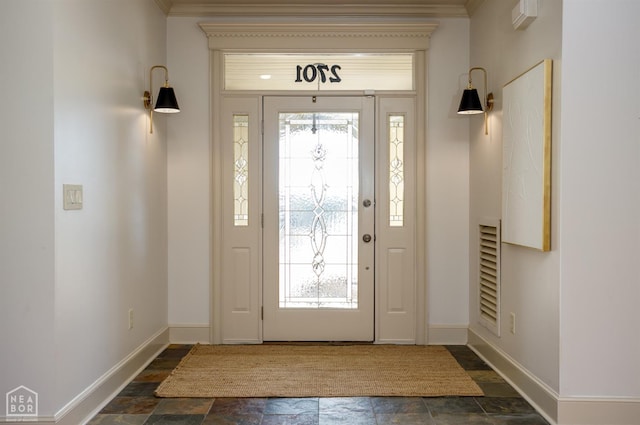 foyer entrance with stone finish flooring, baseboards, and ornamental molding