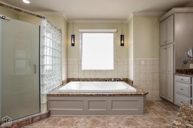 full bathroom featuring a garden tub, vanity, ornamental molding, tile walls, and a stall shower