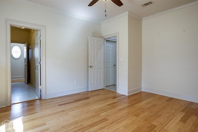 unfurnished bedroom featuring ornamental molding, visible vents, baseboards, and light wood-style floors
