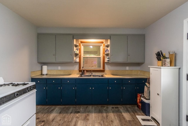 18020 Butterfly Rd, Harrisburg, AR 72432 - kitchen with white range with gas stovetop, dark wood finished floors, light countertops, and blue cabinets