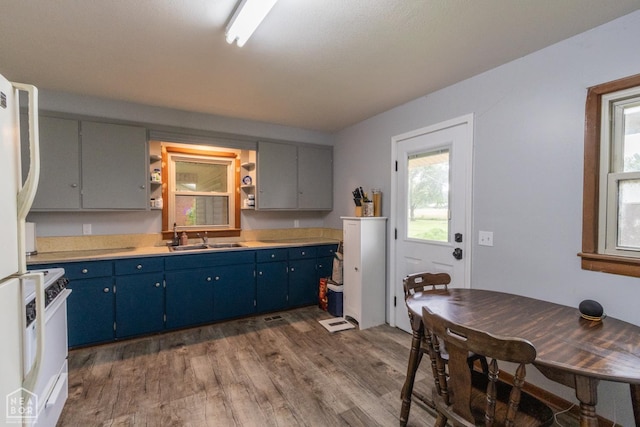 18020 Butterfly Rd, Harrisburg, AR 72432 - kitchen featuring blue cabinetry, dark wood finished floors, range, light countertops, and open shelves