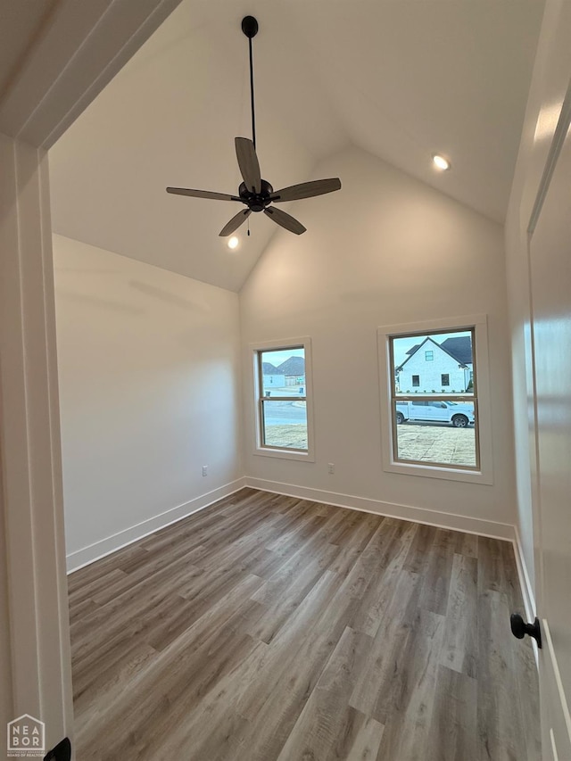 spare room with baseboards, a ceiling fan, recessed lighting, wood finished floors, and high vaulted ceiling