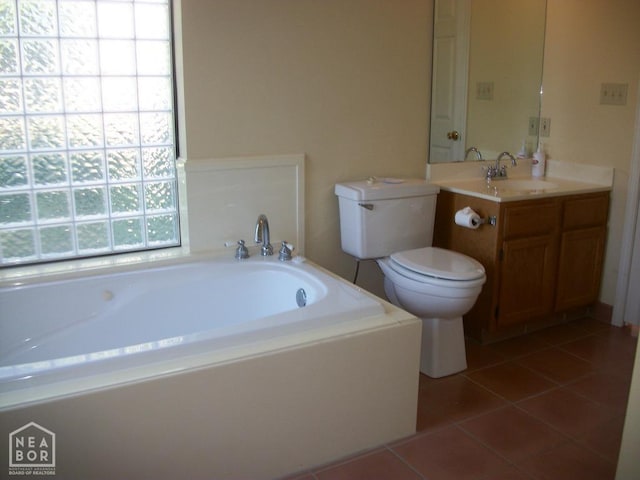 bathroom featuring tile patterned flooring, vanity, a bath, and toilet