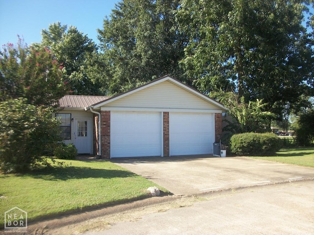 ranch-style home with a front yard, metal roof, a garage, concrete driveway, and brick siding