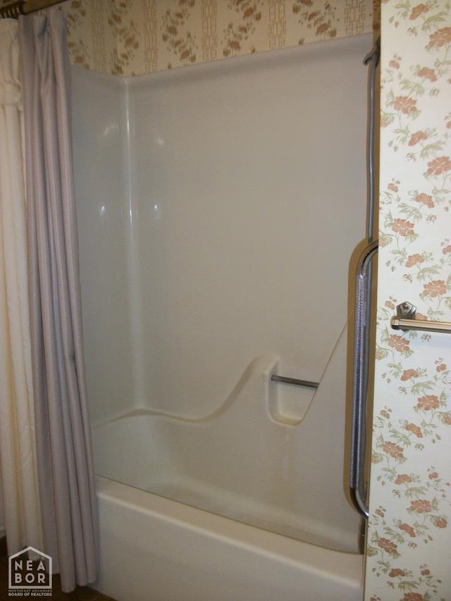 bathroom with shower / tub combo and wallpapered walls