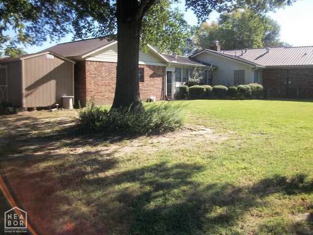 exterior space featuring brick siding and a lawn