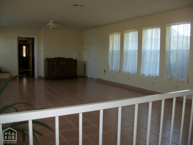 unfurnished living room with tile patterned floors, visible vents, and a ceiling fan