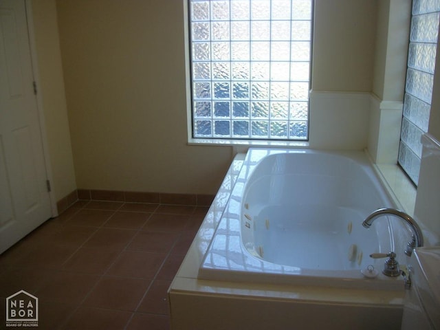 bathroom with a whirlpool tub and tile patterned flooring