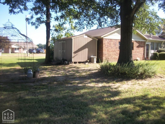view of home's exterior featuring an outbuilding, brick siding, and a lawn