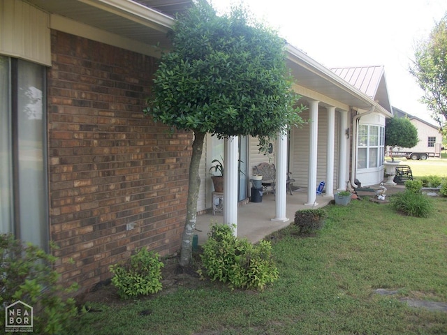 view of side of property featuring a lawn and brick siding