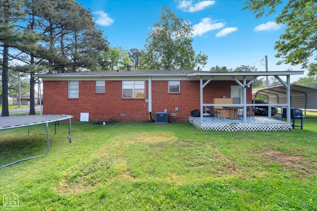 208 S Rockingchair Rd, Paragould, AR 72450 - back of property featuring a trampoline, a lawn, and brick siding