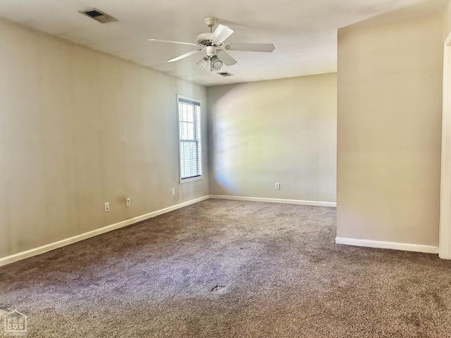 carpeted empty room with baseboards, a ceiling fan, and visible vents