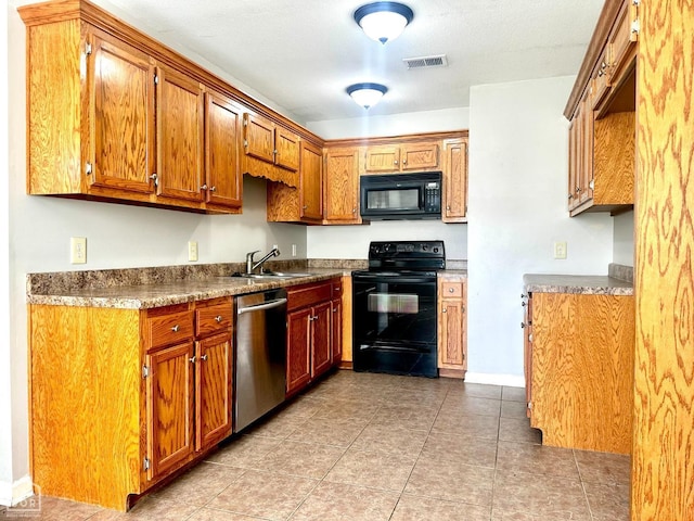 kitchen with brown cabinets, visible vents, a sink, and black appliances