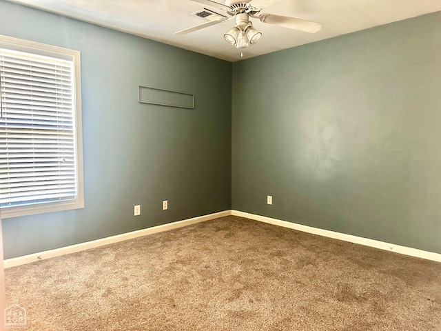 unfurnished room with visible vents, carpet floors, ceiling fan, and baseboards
