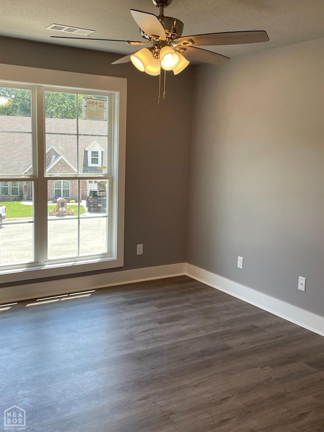 3502 Burdyshaw Dr Drive, Jonesboro, AR 72405 - empty room with dark wood-style flooring, visible vents, baseboards, and a ceiling fan