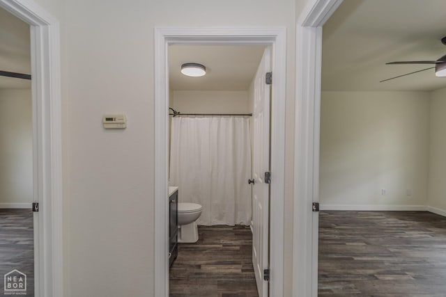 bathroom featuring a ceiling fan, wood finished floors, vanity, baseboards, and toilet