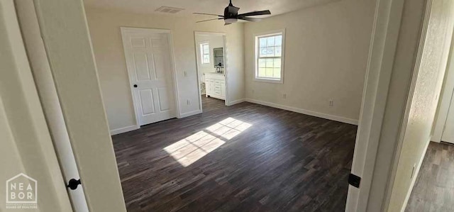 unfurnished bedroom featuring baseboards, dark wood-type flooring, and visible vents