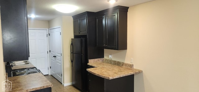 18 Brookland St, Brookland, AR 72417 - kitchen with dark cabinetry, range with electric cooktop, freestanding refrigerator, and light countertops