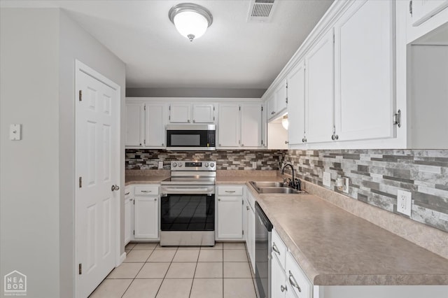 1104 Sandino Dr, Jonesboro, AR 72405 - kitchen with stainless steel appliances, light tile patterned floors, white cabinets, decorative backsplash, and light countertops