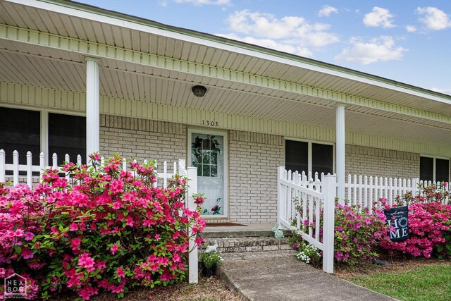 1303 Magnolia Ave, Walnut Ridge, AR 72476 - view of exterior entry with brick siding and covered porch