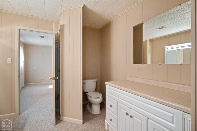 1303 Magnolia Ave, Walnut Ridge, AR 72476 - bathroom with wooden walls, vanity, ornamental molding, and toilet