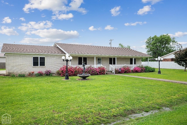 1303 Magnolia Ave, Walnut Ridge, AR 72476 - ranch-style home featuring a front lawn, covered porch, fence, brick siding, and a shingled roof