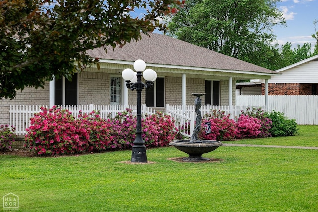 1303 Magnolia Ave, Walnut Ridge, AR 72476 - view of front facade featuring fence, a shingled roof, covered porch, and a front yard
