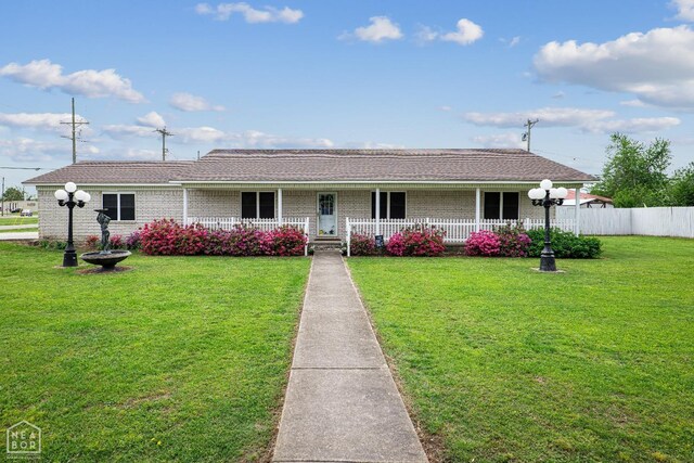 1303 Magnolia Ave, Walnut Ridge, AR 72476 - ranch-style house with brick siding, fence, a front yard, and covered porch