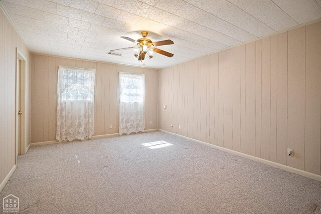 1303 Magnolia Ave, Walnut Ridge, AR 72476 - empty room featuring ceiling fan, wooden walls, visible vents, and carpet
