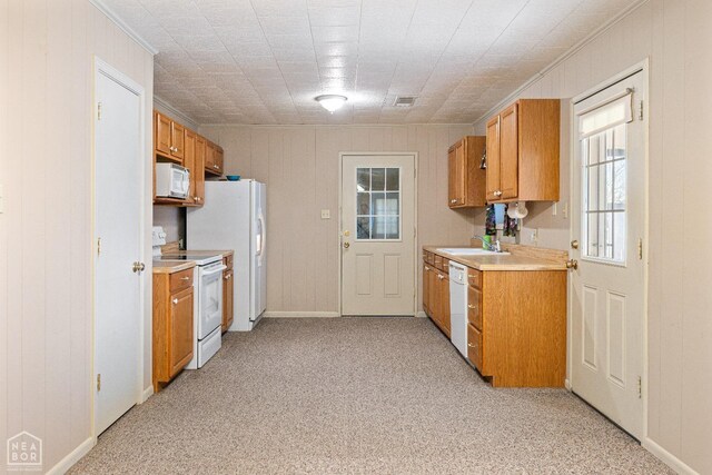 1303 Magnolia Ave, Walnut Ridge, AR 72476 - kitchen featuring brown cabinets, light countertops, light carpet, a sink, and white appliances