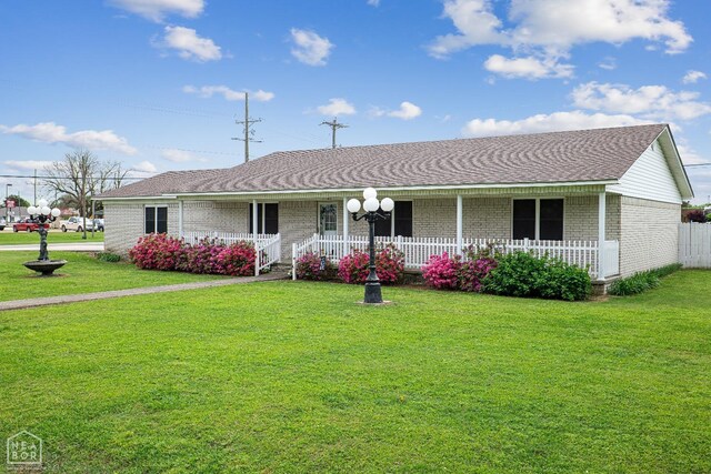 1303 Magnolia Ave, Walnut Ridge, AR 72476 - ranch-style home featuring a porch, a shingled roof, brick siding, and a front yard