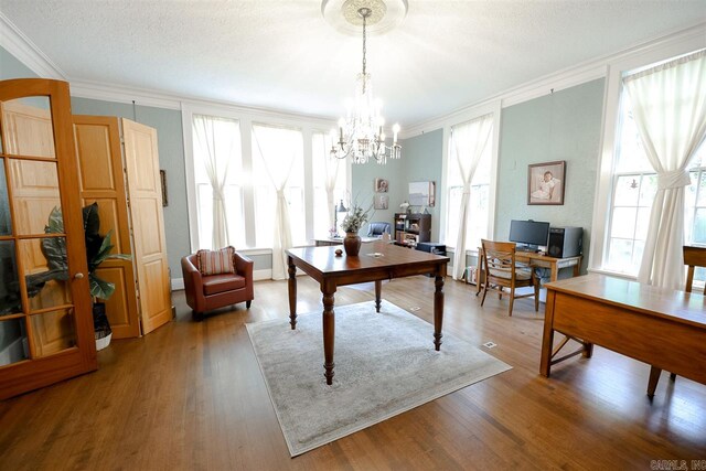 office area with an inviting chandelier, hardwood / wood-style floors, and ornamental molding